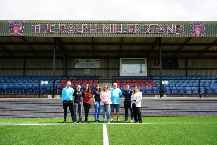 people standing in front of a football pitch